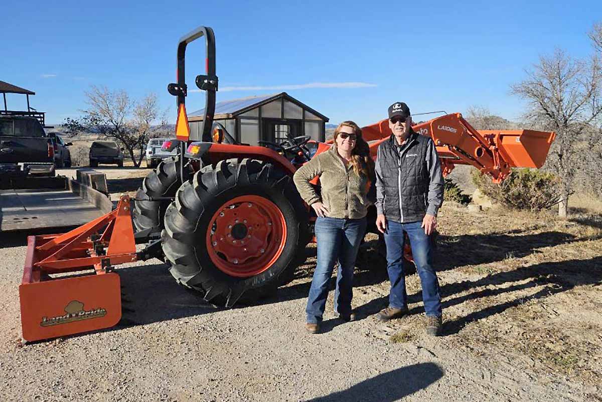 Chelsey Stimson and her local Kubota dealer pose with her new tractor